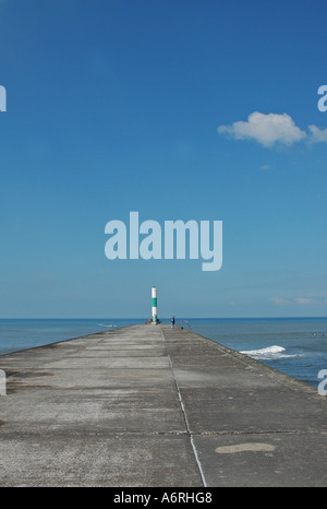 Parete di porto con luce di navigazione alla fine sotto un cielo blu Foto Stock