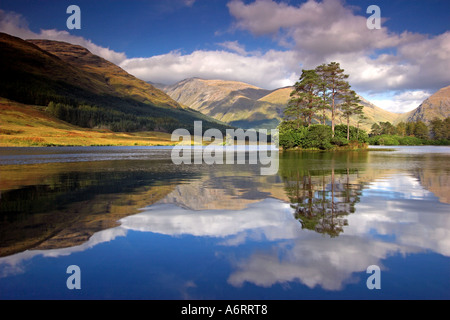 Un riflesso perfetto a Glen Etive nelle Highlands Scozzesi. L'unica isola, inondata di sole si siede con orgoglio sul Loch. Foto Stock