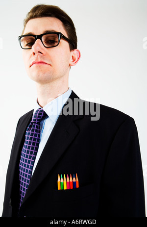 BUSINESS MAN in abito scuro indossando spesse e pesanti vetri bordati con colore matite di colore nella sua tasca sul petto Foto Stock