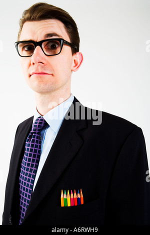 BUSINESS MAN in abito scuro indossando spesse e pesanti vetri bordati con colore matite di colore nella sua tasca sul petto Foto Stock
