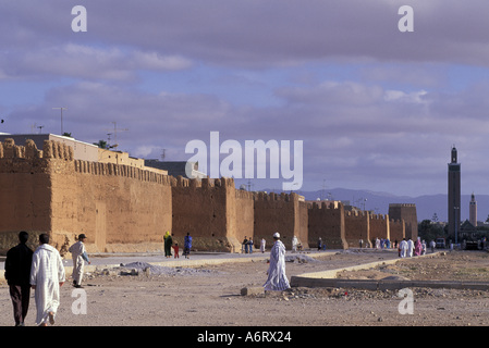 Africa, Marocco, Tiznit uomini in tradizionale djellabas (cappa mantelli) a piedi in strada sotto vecchie mura della città Foto Stock