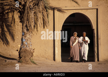 Africa, Marocco, Taroudant, velata donne musulmane a piedi attraverso arch nel vecchio pise (mattone di fango) parete della città Foto Stock