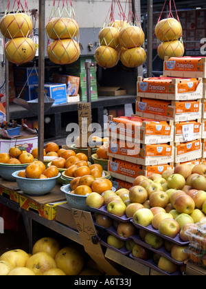 Arance e mele, e pummelos per la vendita in un esterno di frutta stand nel quartiere di Chinatown di Manhattan. Foto Stock