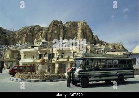 Villaggio di Maaloula, Siria - case ai piedi del Mar Sarkis convento e un autista di autobus con il suo bus Foto Stock