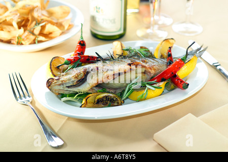 Appena pescato cotto Spigola farcita con finocchio servito con arrosti di carne rossa chilis lime di rosmarino e di timo Foto Stock