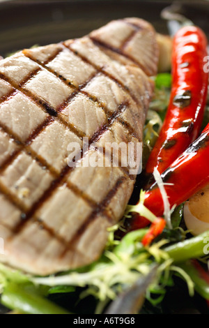 Ai ferri Bistecca di tonno servita con fagiolini uova sode, filetti di acciughe e insalata verde Foto Stock