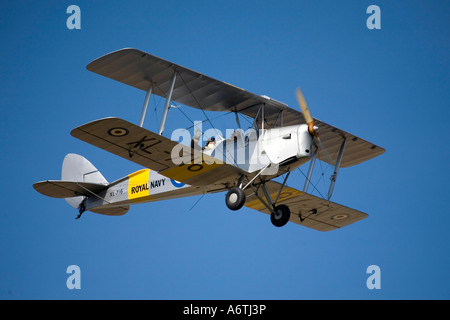 Avendo un piacere di volo in un DH62 Tiger Moth a Compton Abbas Airfield in Dorset in un cielo blu Foto Stock