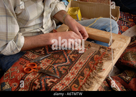 Un tessitore lavora su un tappeto tradizionale in un laboratorio di tessitura di tappeti ad Antalya in Turchia Foto Stock