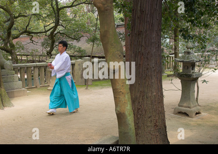 Giappone Ehime Omishima arcipelago isola santuario Oyamazumi sacerdote nel tradizionale abito blu e sandali in legno a piedi attraversata la Foto Stock