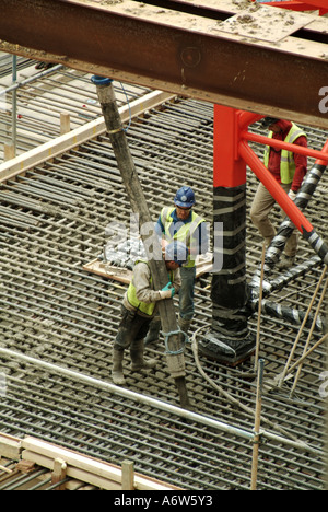 Londra fondazioni profonde per il nuovo blocco di ufficio in costruzione mostra ready mix concrete il collocamento da parte della pompa dal tubo flessibile Foto Stock