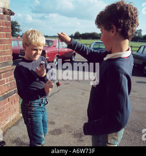 Giocare a Conkers nel parco giochi della scuola Herts UK Autunno Foto Stock