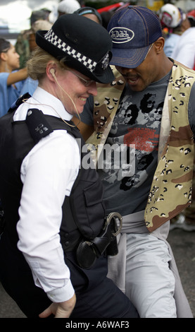 Poliziotta ballando con uomo a nottinghill carnival nottinhill Foto Stock