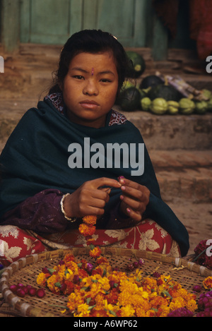 Asia, Nepal, Valle di Kathmandu, Bhaktapur. Ragazza indù vende calendula fiori, Tihar è Dipawali Festival. Foto Stock