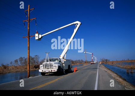 Dopo l'uragano Rita surge devastanti in 2005, linea equipaggi di costruire nuove linee di trasmissione su Louisiana Highway 27. Foto Stock