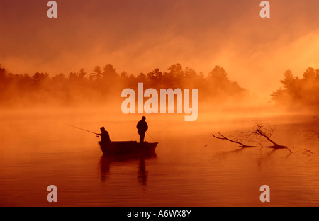 Due pescatori al mattino presto nebbia su un tranquillo lago canadese che mostra una mattina tranquilla e tranquilla sotto una luce incredibile. Buckhorn, Ontario, Canada Foto Stock