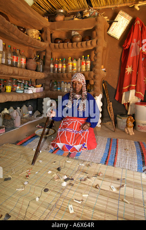 Un tradizionale sangoma gettando e la lettura di vari oggetti che lei utilizza per consultazioni nelle township di Refilwe in Sud Africa. Foto Stock