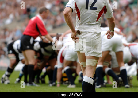 Un Inghilterra giocatore di rugby tergi la sua mano mentre un scrum è impostato Foto Stock