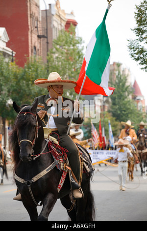 ILLINOIS Chicago uomo vestito nel tradizionale costume cowboy carry flag il giorno dell indipendenza messicana Parade Pilsen Foto Stock