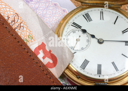 Il tempo è denaro orologio d'oro con denaro sul portafoglio in pelle Foto Stock