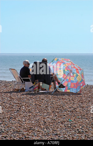 Coppie anziane sedute sulla spiaggia a Goring-by-Sea, West Sussex, Inghilterra Foto Stock