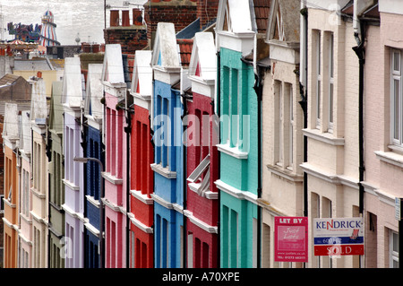 Luminosamente verniciato multicolori case a schiera in Blaker Street Brighton East Sussex con il mare e gli Helter Skelter in distanza Foto Stock