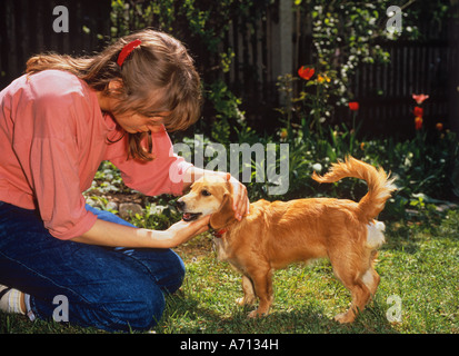 Giovane donna petting un cane Foto Stock