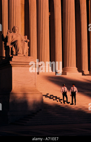 Due poliziotti in uniforme in piedi sui gradini di U corte suprema nella luce di un tramonto Washington D C Foto Stock