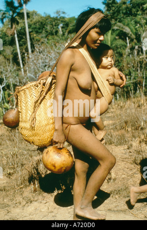 Panare madre indiana trasporto bambini mentre si cammina nella savana altipiani della Guyana Venezuela Foto Stock