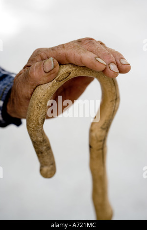 Close up di un anziano pastore di montagna s mano che poggia su un bastone da passeggio Creta Foto Stock