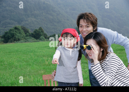 Famiglia avente picnic, madre utilizzando un binocolo Foto Stock