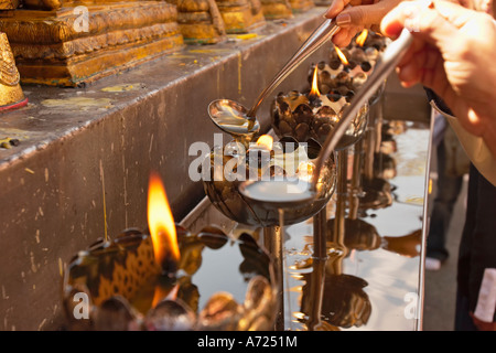 Rituale di aggiunta di olio per le lampade in Wat Phrathat Doi Suthep, altamente venerato tempio buddista in Chiang Mai, Thailandia. Foto Stock