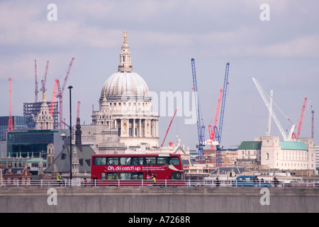 St Pauls Cathedral e il bus rosso attraversando un ponte sul fiume Tamigi con numerose gru Londra Inghilterra Foto Stock