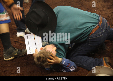 Professional bullrider Chris brividi in agonia dopo un toro passi sulla sua gamba. Honolulu, HI Foto Stock