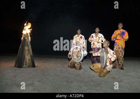 Musicisti africani a suonare le percussioni su una spiaggia di notte Foto Stock
