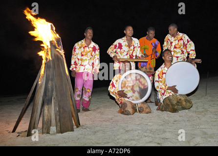 Musicista africano a suonare le percussioni su una spiaggia di notte Foto Stock