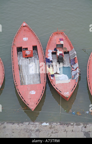 Riga barche ormeggiate lungo il fiume Gange a Varanasi, India Foto Stock