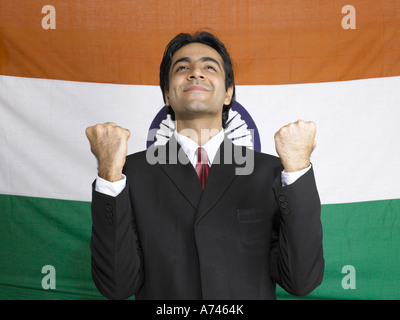 VDA 201919 South Asian executive indiani guardando al di sopra elevare i pugni in piedi di fronte a bandiera di India in background MR 702A Foto Stock