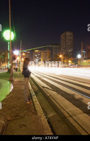 Attraversamento pedonale di notte lungo la baia di Manila Foto Stock