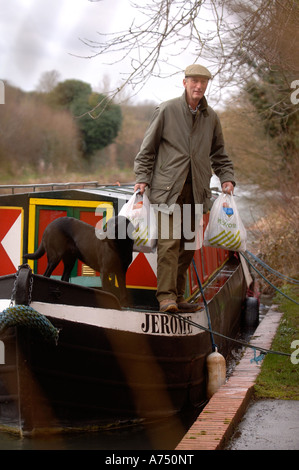 Un uomo passi fuori un canal chiatta ormeggiata al di fuori di un mulino sul KENNET E AVON vicino a Hungerford Regno Unito Foto Stock