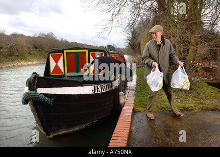 Un uomo passi fuori un canal chiatta ormeggiata al di fuori di un mulino sul KENNET E AVON vicino a Hungerford Regno Unito Foto Stock
