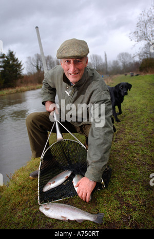 Un coltivatore di pesce con esemplari di trota REGNO UNITO Foto Stock