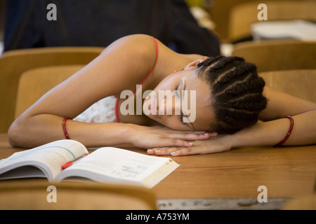 Studentessa di dormire sulla scrivania Foto Stock