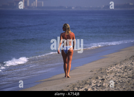 Lone donna cammina lungo la spiaggia di Puerto Vallarta Messico Foto Stock