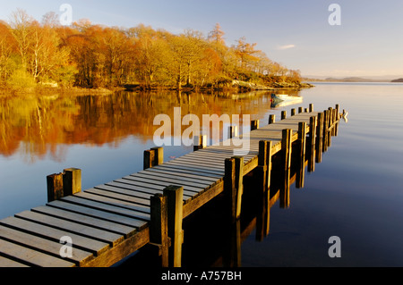 Fine luce sul pontile in legno e le barche a remi Loch Lomond Scozia UK Foto Stock