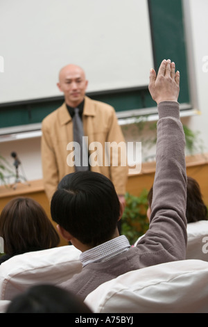 Studente di College alzando la mano in classe Foto Stock