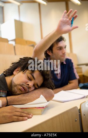 Studente maschio dorme in classe Foto Stock