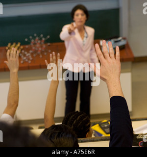Gli studenti ad alzare la mano in classe Foto Stock