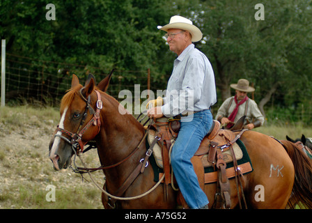 Un cowboy a cavallo in Bandera Foto Stock