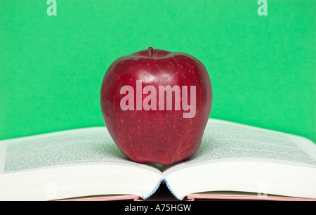 Mela rossa sulla parte superiore di aprire un libro di testo Foto Stock