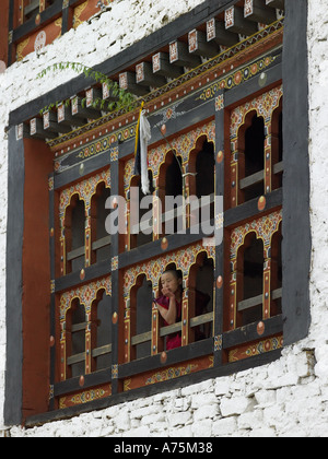 Monaco buddista guardando fuori da una finestra a paro Dzong nel Regno del Bhutan Foto Stock